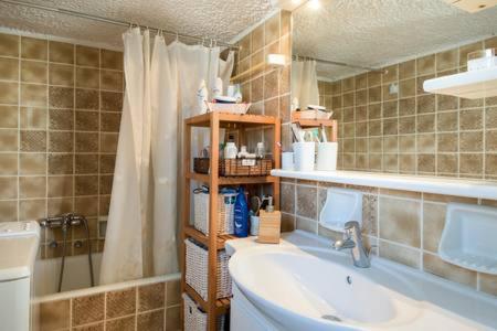 a bathroom with a sink and a tub and a shower at Varkiza Apartment in Varkiza