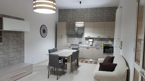 Solarino的住宿－A casa di Pamy，厨房以及带桌椅的用餐室。