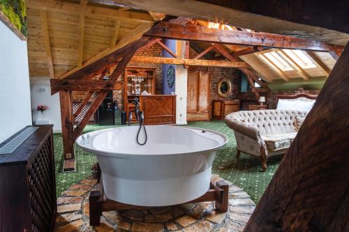 uma banheira num quarto com tecto em madeira em JMR Royal em Constança