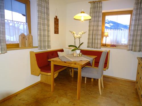 uma sala de jantar com uma mesa de madeira e cadeiras em Anna's Appartement em Alpbach