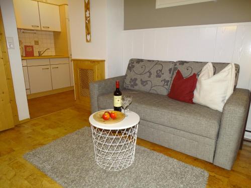 a living room with a couch and a table with a bottle of wine at Anna's Appartement in Alpbach