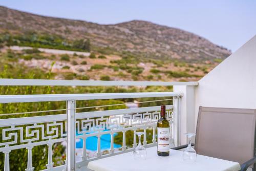 a bottle of wine sitting on a table on a balcony at Evelin hotel in Pythagoreio