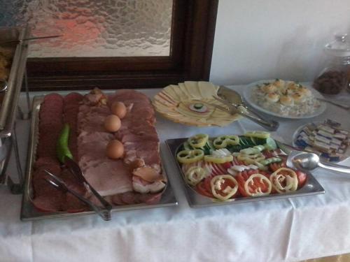 a table with plates of food on a table at Gasthof Laci Betyár in Hajdúszoboszló