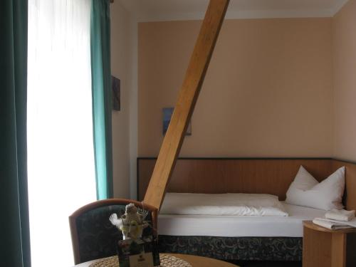 a bedroom with a bed with a ladder on it at Pension Kastanienhof in Zeulenroda
