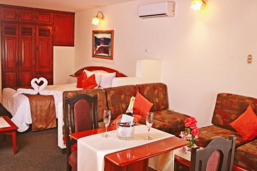 a hotel room with a bed and a couch and a table at Apart Hotel Caminos del Inca in Lima