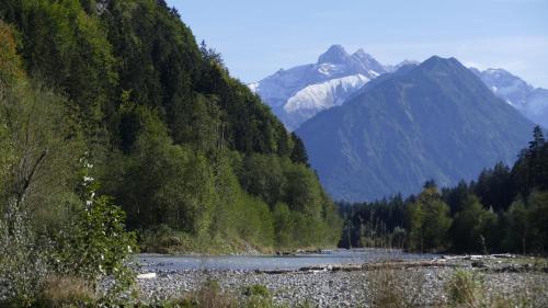 a river in a valley with a mountain at Ferienwohnung Mathias Kennerknecht in Fischen
