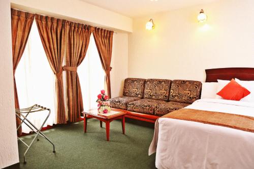 a hotel room with a bed and a couch at Apart Hotel Caminos del Inca in Lima