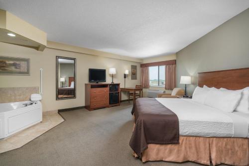 a hotel room with a large bed and a bathroom at AmericInn by Wyndham Newton in Newton