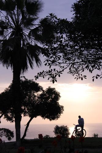 a man riding a bike in front of a sunset at Apart Hotel Caminos del Inca in Lima
