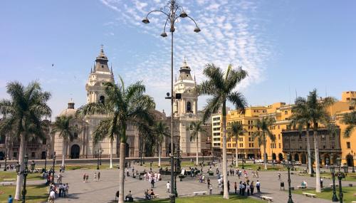 a large building with palm trees in front of it at Apart Hotel Caminos del Inca in Lima