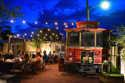 a group of people sitting at tables outside a restaurant at Painted Lady Bed & Brew in Albuquerque