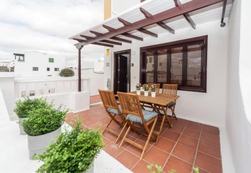 a patio with a wooden table and chairs at Luxury Beach Apartments II in Playa Honda