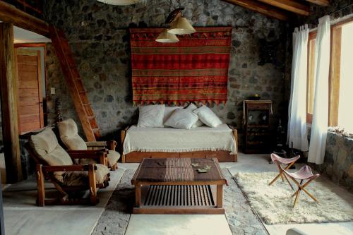 Un dormitorio con una cama y una mesa. en Casa de Piedra en Potrerillos