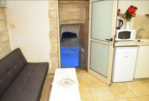 a living room with a refrigerator and a kitchen at Lake Mansion in Tiberias