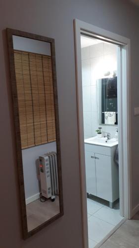 a mirror reflecting a bathroom with a sink and a mirror at Casinha do Cedro in Baião