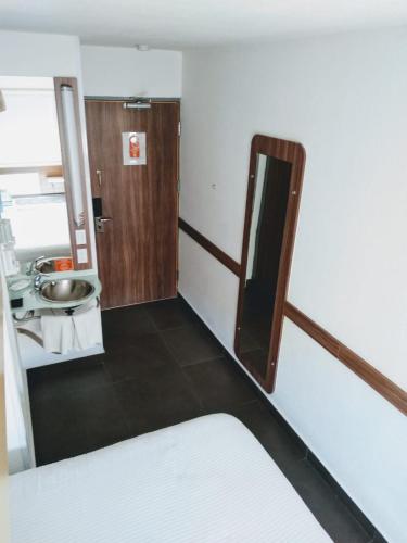a small bathroom with a sink and a mirror at Hotel Hi ! Torreon Aeropuerto-Galerías in Torreón
