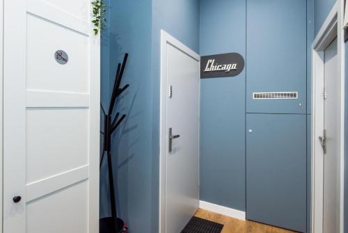 a hallway with blue walls and a door with a sign at Bliss Apartments in Poznań