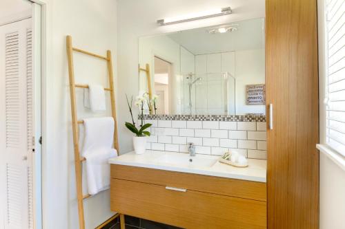 ein Bad mit einem Waschbecken und einem Spiegel in der Unterkunft Eight on Church - near Mudbrick & Cable Bay in Oneroa