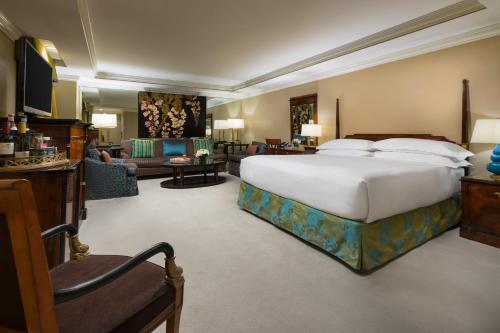 a bedroom with a large bed and a living room at The Michelangelo Hotel in New York
