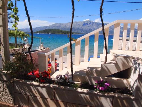 a staircase with flowers on it next to the water at Apartments Lumbarda Beach in Lumbarda