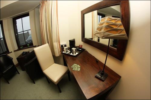 a room with a desk with a mirror and a chair at All the Twos Lodge in Clifden