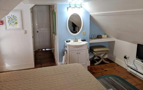 Schlafzimmer mit einem Bett, einem Waschbecken und einem Spiegel in der Unterkunft Elms of Camden in Camden