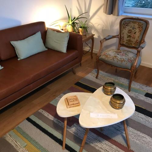 a living room with a couch and a chair at De Notelaar in Kortessem