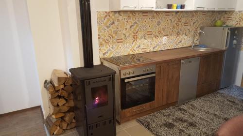 a kitchen with a stove with a pile of wood at Lumer in Kolašin