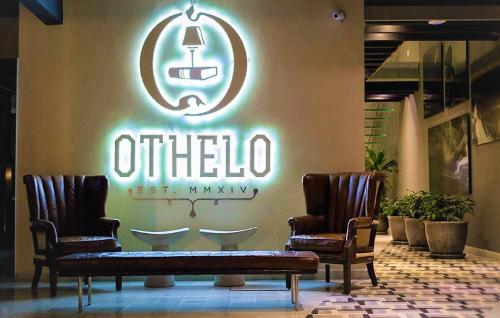 two chairs and a sign on the wall of a store at Othelo Boutique Hotel Mexico in León