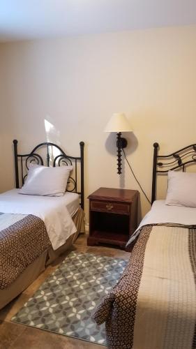 a bedroom with two beds and a table with a lamp at Rothesay Motel in Rothesay