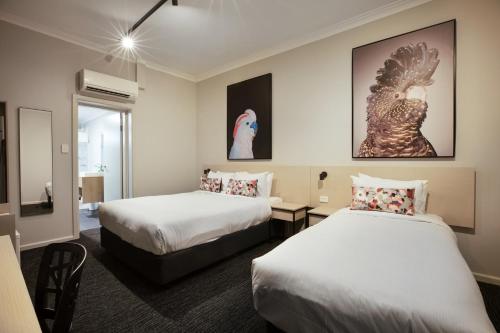 a hotel room with two beds and a window at Nightcap at the Charles Hotel in Wollongong