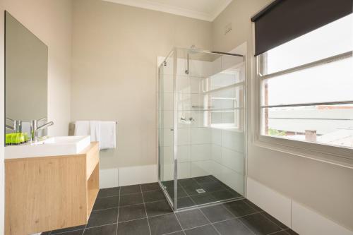 a bathroom with a shower and a sink at Nightcap at the Charles Hotel in Wollongong