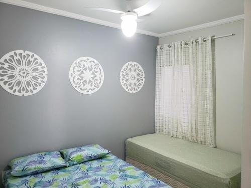 a bedroom with two beds and white plates on the wall at Apartamento Cabo Frio in Cabo Frio