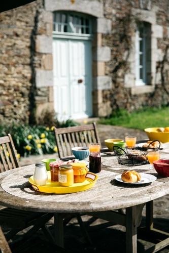 une table en bois avec de la nourriture dessus dans l'établissement La Vieille Foulonnière : Chambres d'hôtes & Permaculture, à Pontorson