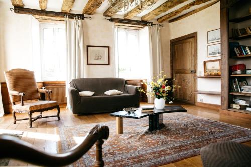 蓬托尔松La Vieille Foulonnière : Chambres d'hôtes & Permaculture的带沙发和咖啡桌的客厅