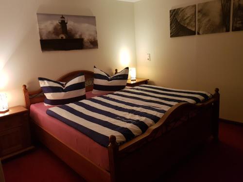 a bedroom with a bed with blue and white striped pillows at Kleine Auszeit in Stolpe auf Usedom