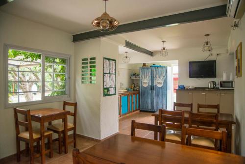 a dining room with a table and chairs and a kitchen at Feliza Hostel in Villa Carlos Paz