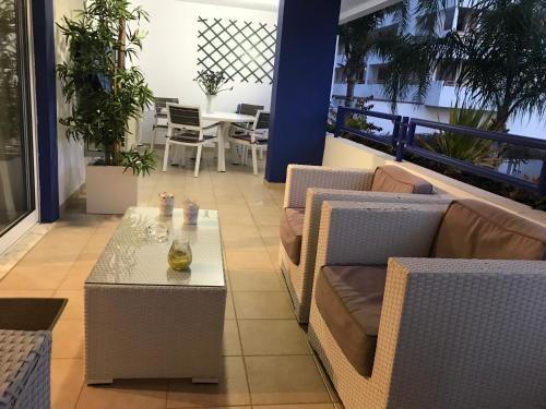 a patio with couches and a table on a balcony at Timeless Vacations Vilamoura Marina Flat WIFI & Pool in Vilamoura