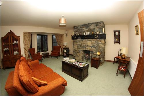 a living room with a couch and a stone fireplace at All the Twos Lodge in Clifden