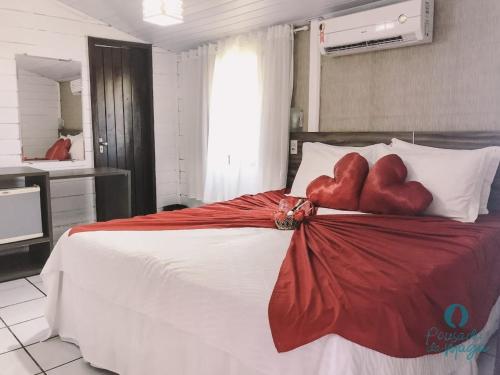 um quarto com dois corações vermelhos numa cama em Pousada da Maga em Fernando de Noronha