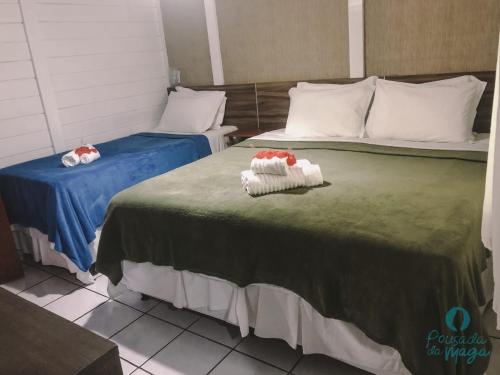 a hotel room with two beds with towels on them at Pousada da Maga in Fernando de Noronha