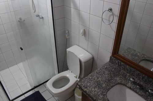 a bathroom with a toilet and a shower and a sink at Flat Abolicao in Fortaleza