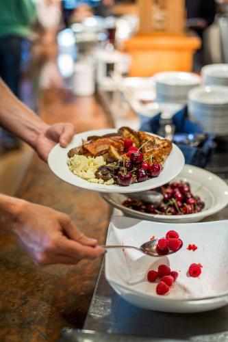 une personne détenant deux assiettes alimentaires sur une table dans l'établissement Sleeping Lady Mountain Resort, à Leavenworth