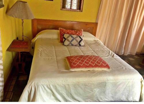 a bed in a room with a table and a lamp at Acogedor in Quillota
