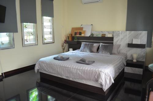 a bedroom with a large bed with white sheets at Modern room at Sabai Sabai Homestay Ayutthaya in Phra Nakhon Si Ayutthaya