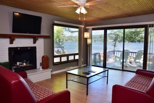a living room with a couch and a fireplace and a television at Delton Oaks Resort Motel in Wisconsin Dells