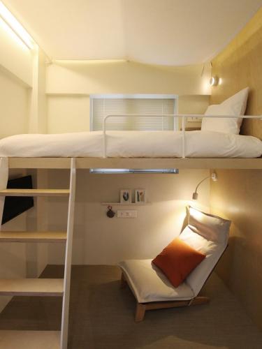 a small room with two bunk beds and a chair at Tong Tong Petit Hotel in Seoul