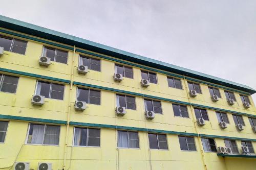 a yellow building with windows and air conditioning at Hotel Sunrise in Onagawa