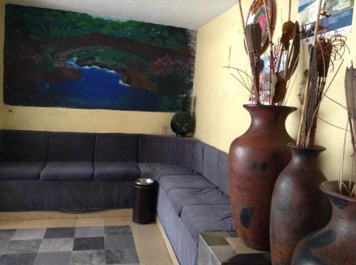 a living room with a couch and two large vases at Hotel Palacio in Uruapan del Progreso