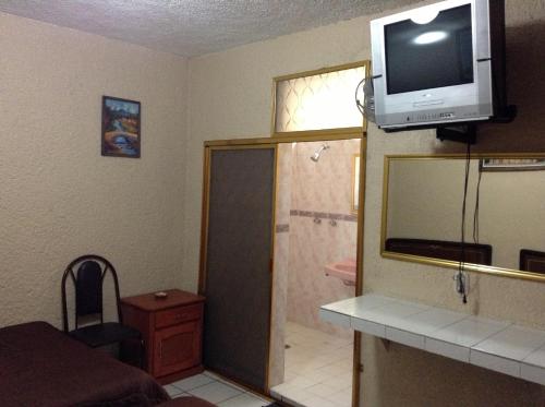 La salle de bains est pourvue d'une télévision au-dessus d'un miroir. dans l'établissement Hotel Palacio, à Uruapan del Progreso